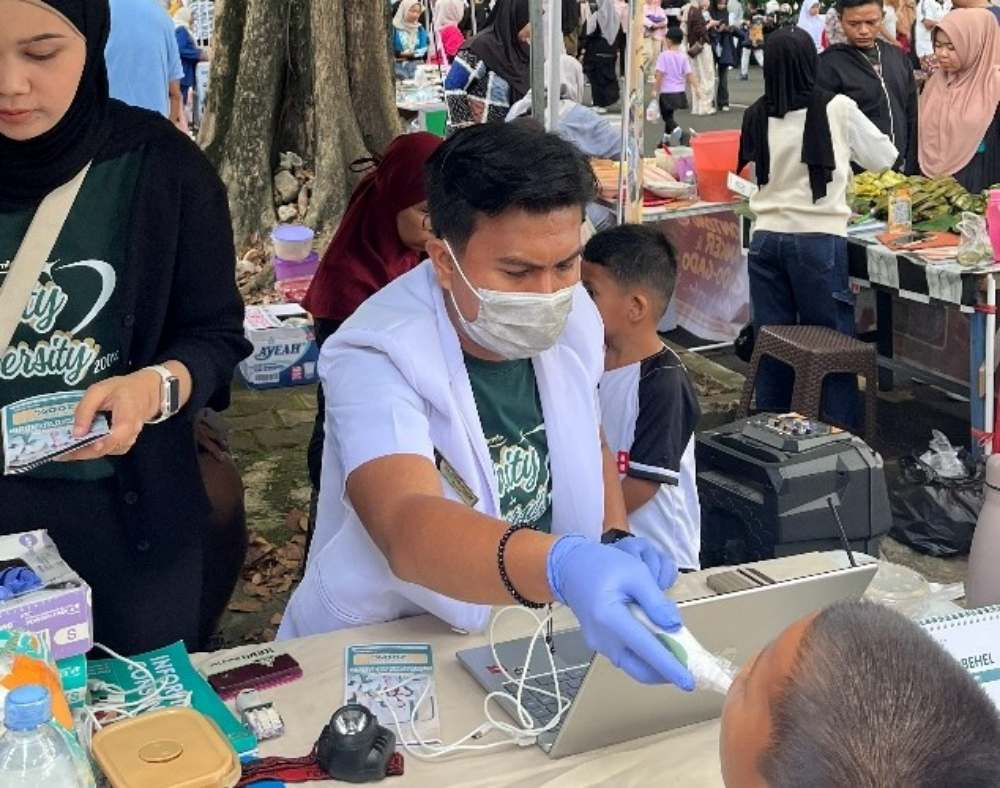 Dokter gigi Farhan Wiranda menggunakan kamera intraoral untuk memeriksa kondisi kesehatan gigi anak secara mendalam pada ajang Car Free Day di GOR Haji Agus Salim.