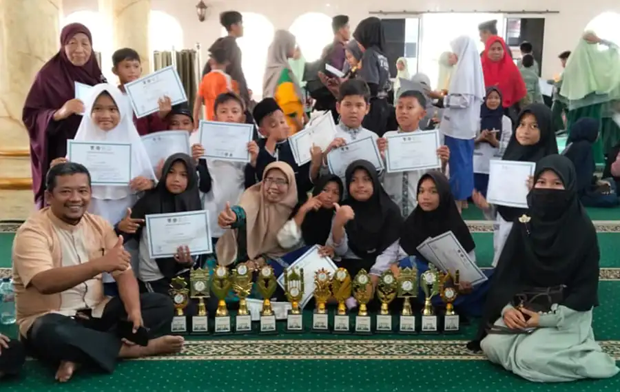 Pengurus MDTA Bustanul Huda, Kelurahan Ulak Karang Selatan, Kecamatan Padang Utara, Kota Padang, berfoto bersama santri yang berhasil meraih gelar juara pada Pekan Olahraga dan Seni Antar Diniyah (Porsadin) ke-11 Tingkat Kecamatan Padang Utara, di MDTA Masjid At Taqwa, Air Tawar Barat, Minggu (27/9/2026).