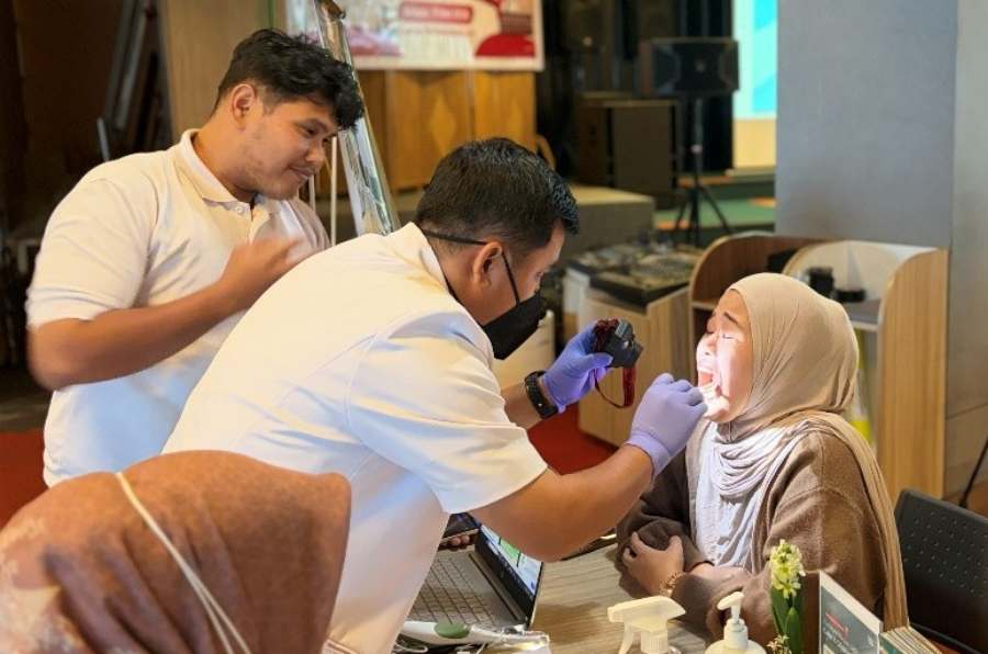 Tim dokter GAIA Dental Clinic memanfaatkan peranti kamera intraoral canggih untuk memeriksa kondisi gigi seorang pasien wanita.